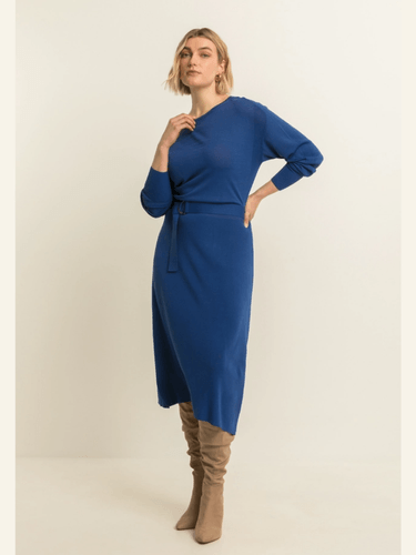 vrouw in een strakke jurk die de taille benadrukt in een soepele stof die meebeweegt met de rondingen.